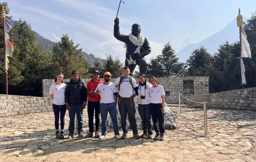 Trekkers posing at the Tenzing Norgay Statue in Namche Bazaar